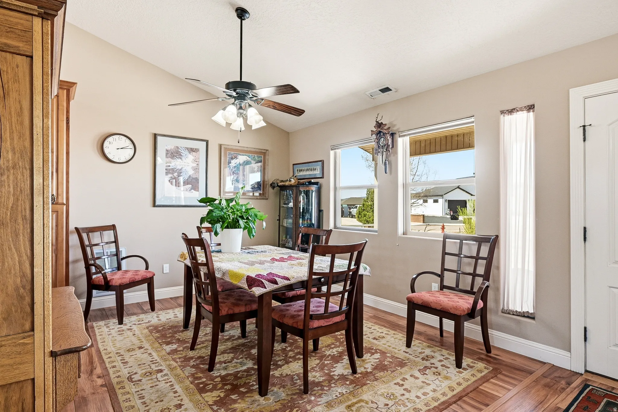 Dining room with vaulted ceiling, light wood-style flooring, and a ceiling fan