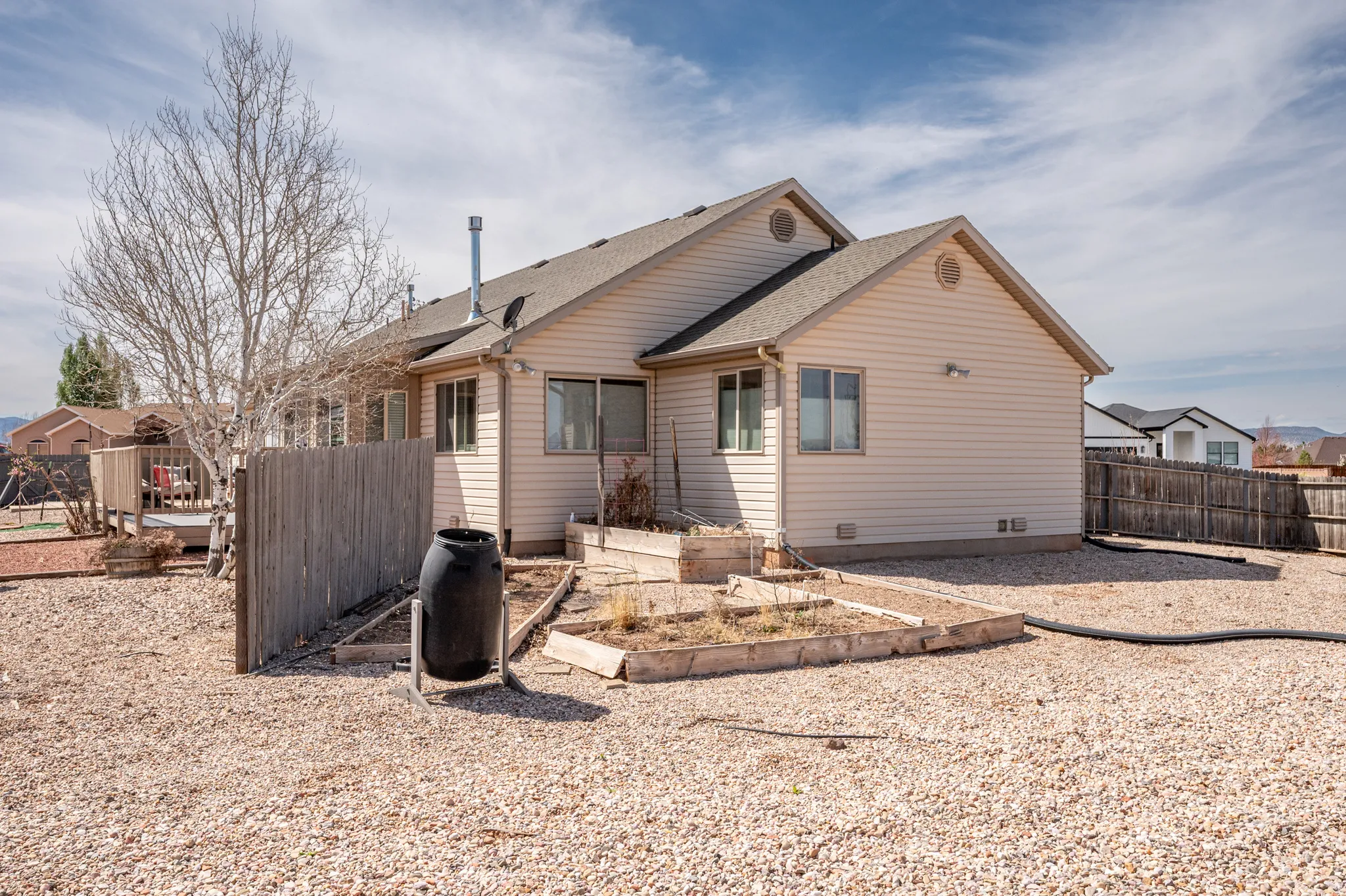 Rear view of property with a garden, a shingled roof, and a fenced backyard
