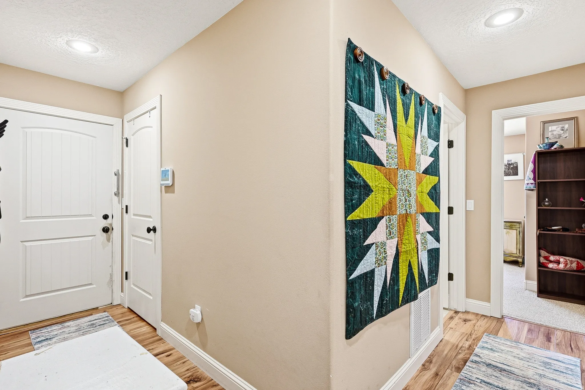Entryway with light wood-type flooring, a textured ceiling, and recessed lighting