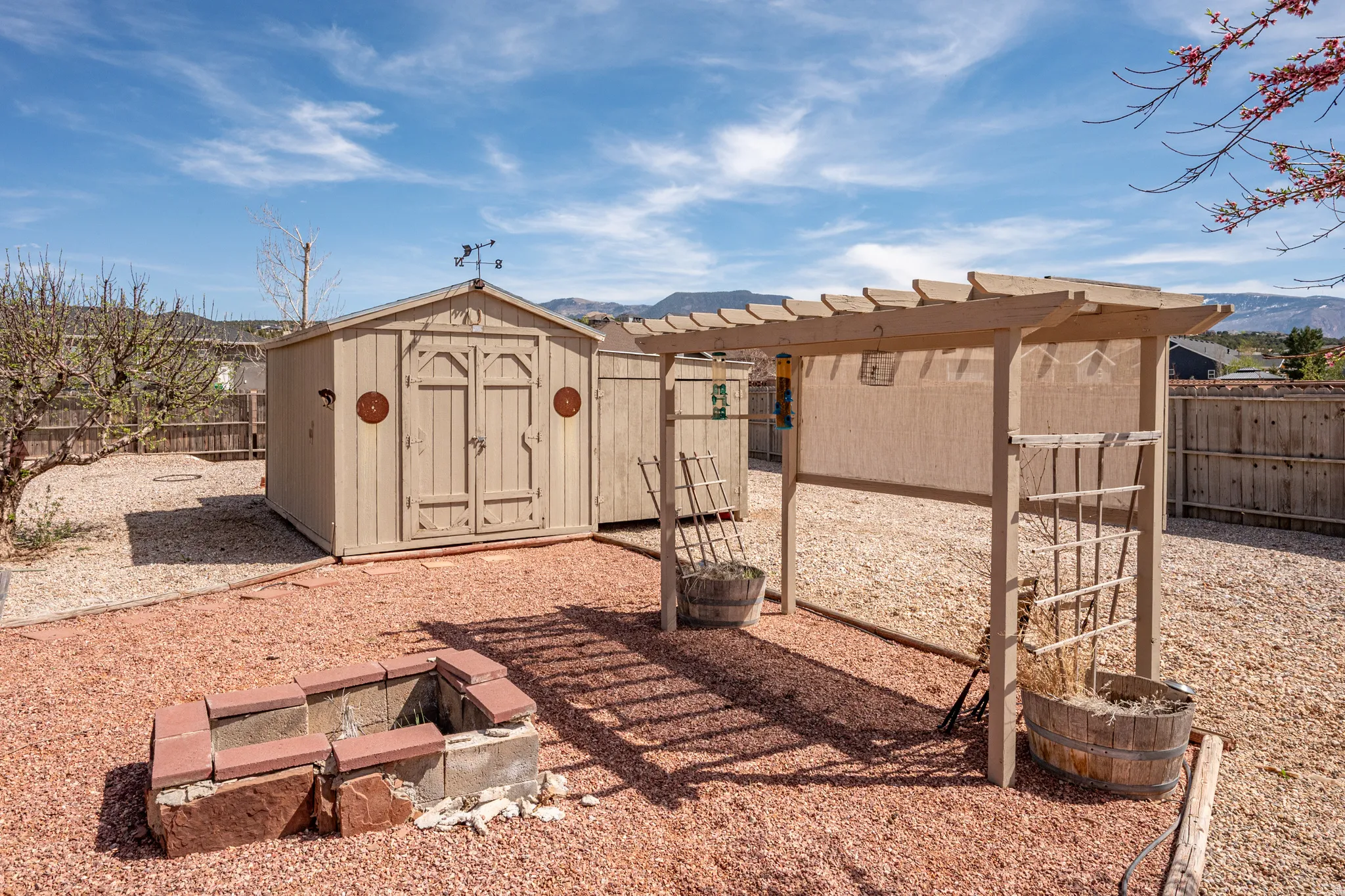 View of shed featuring a mountain view, a fenced backyard, and a fire pit