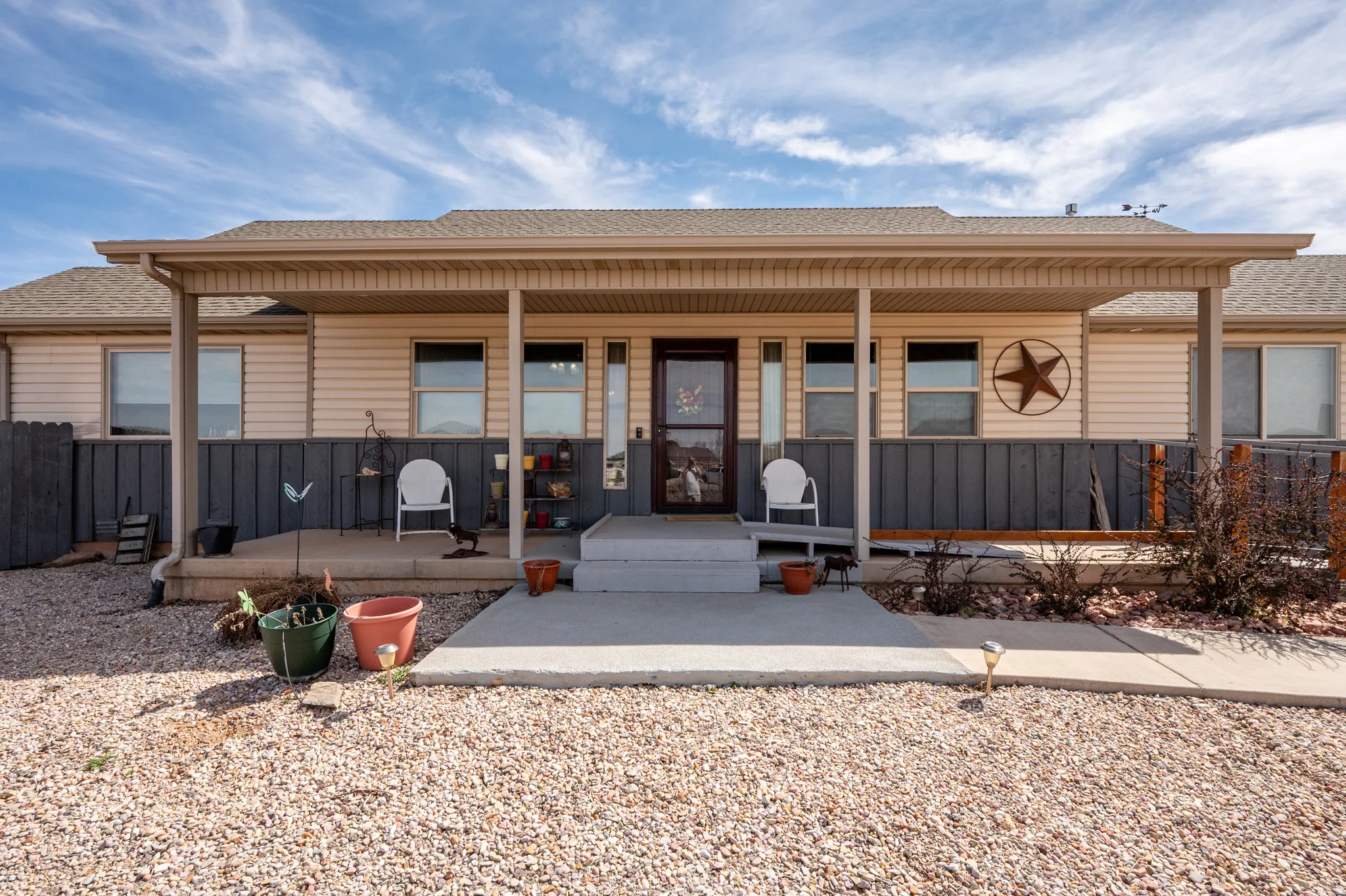 Rear view of house with roof with shingles and covered porch