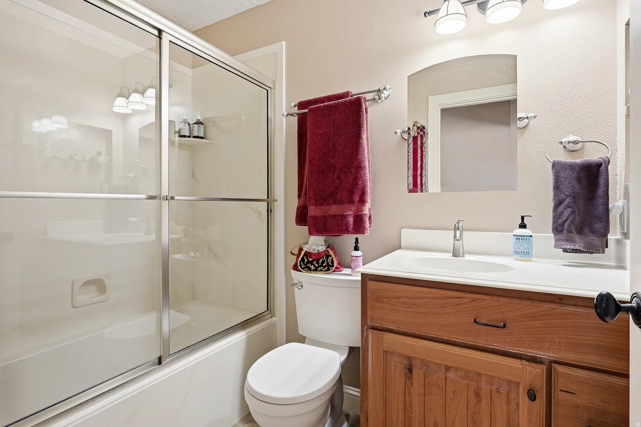 Full bathroom featuring vanity and enclosed tub / shower combo
