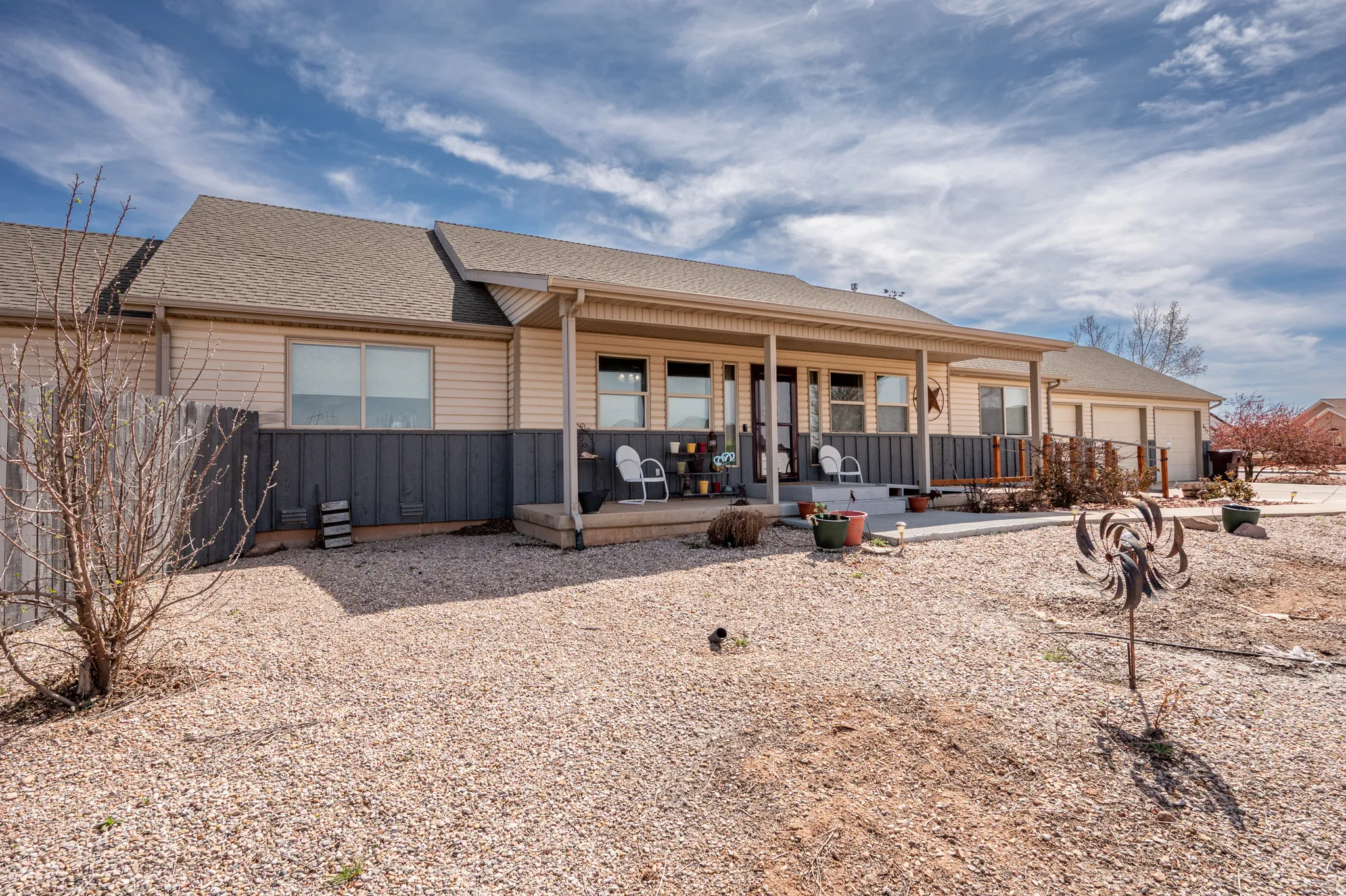 Back of property featuring a shingled roof, covered porch, and a garage
