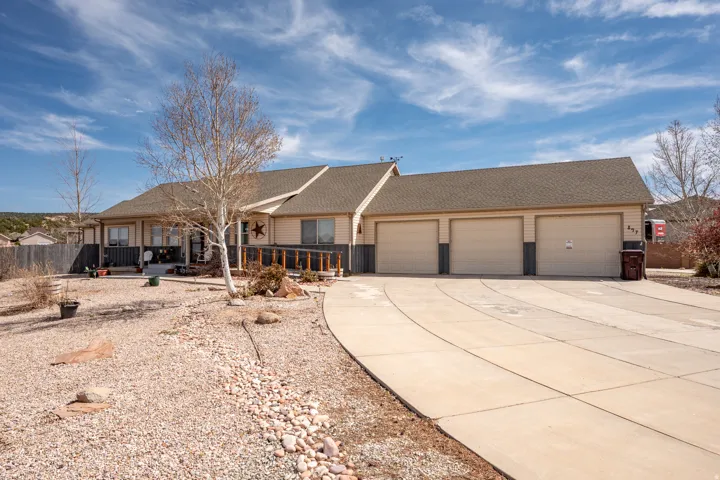 Ranch-style house with a shingled roof, driveway, and an attached garage