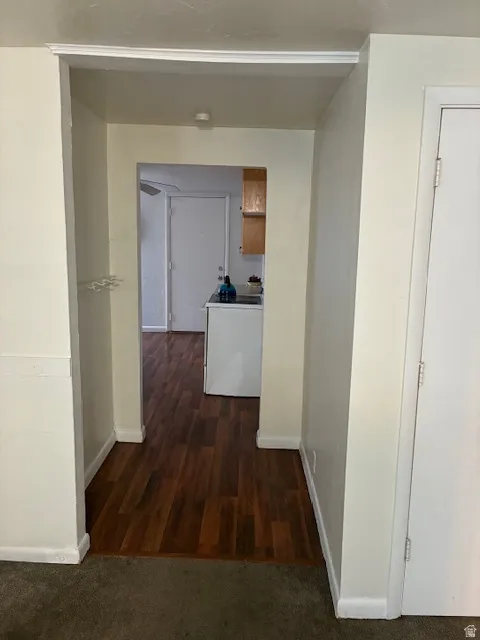 Corridor featuring baseboards and dark wood-style flooring