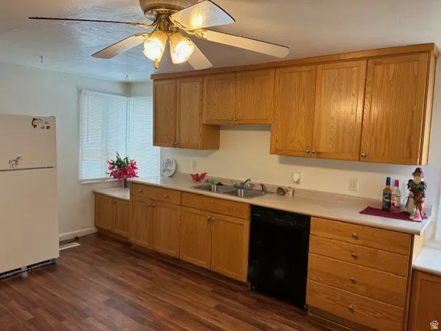 Kitchen featuring freestanding refrigerator, light countertops, a ceiling fan, dishwasher, and dark wood finished floors
