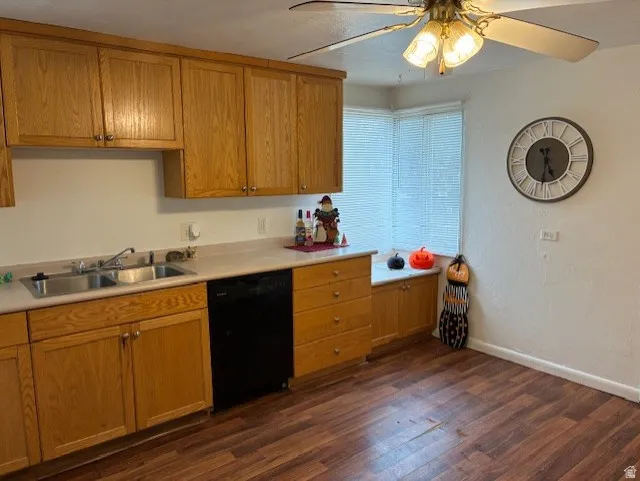 Kitchen featuring light countertops, dishwasher, ceiling fan, dark wood-style floors, and wood finish cabinets