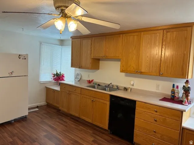 Kitchen featuring light countertops, freestanding refrigerator, black dishwasher, ceiling fan, and dark wood-style floors