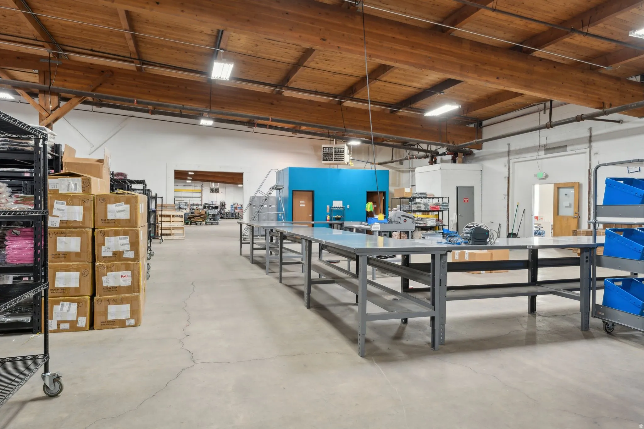 Misc room with a high ceiling, a workshop area, a garage, and a heating unit