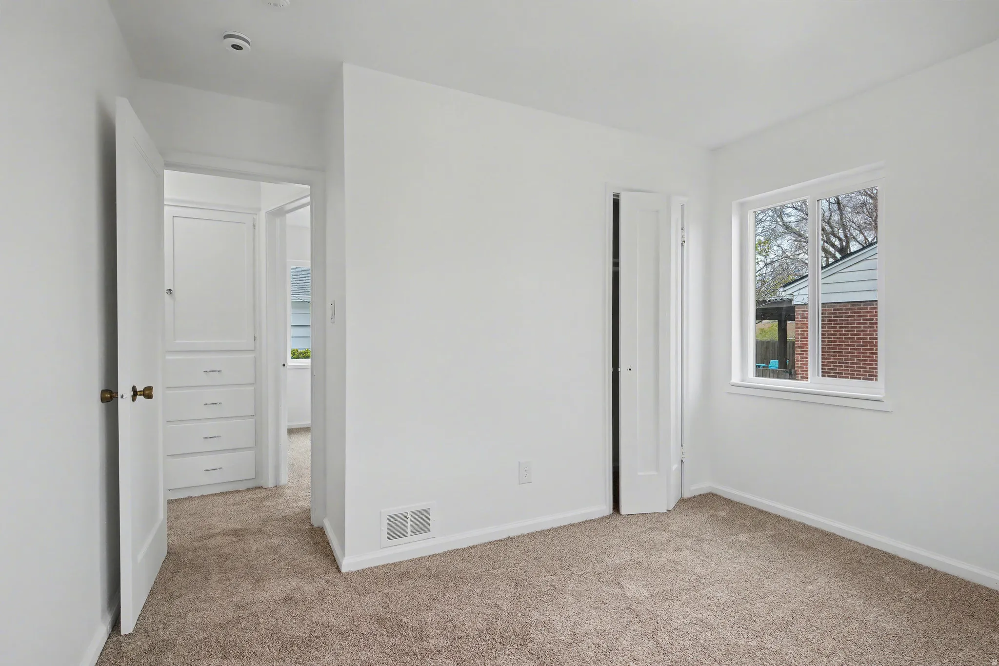 Unfurnished bedroom with light colored carpet