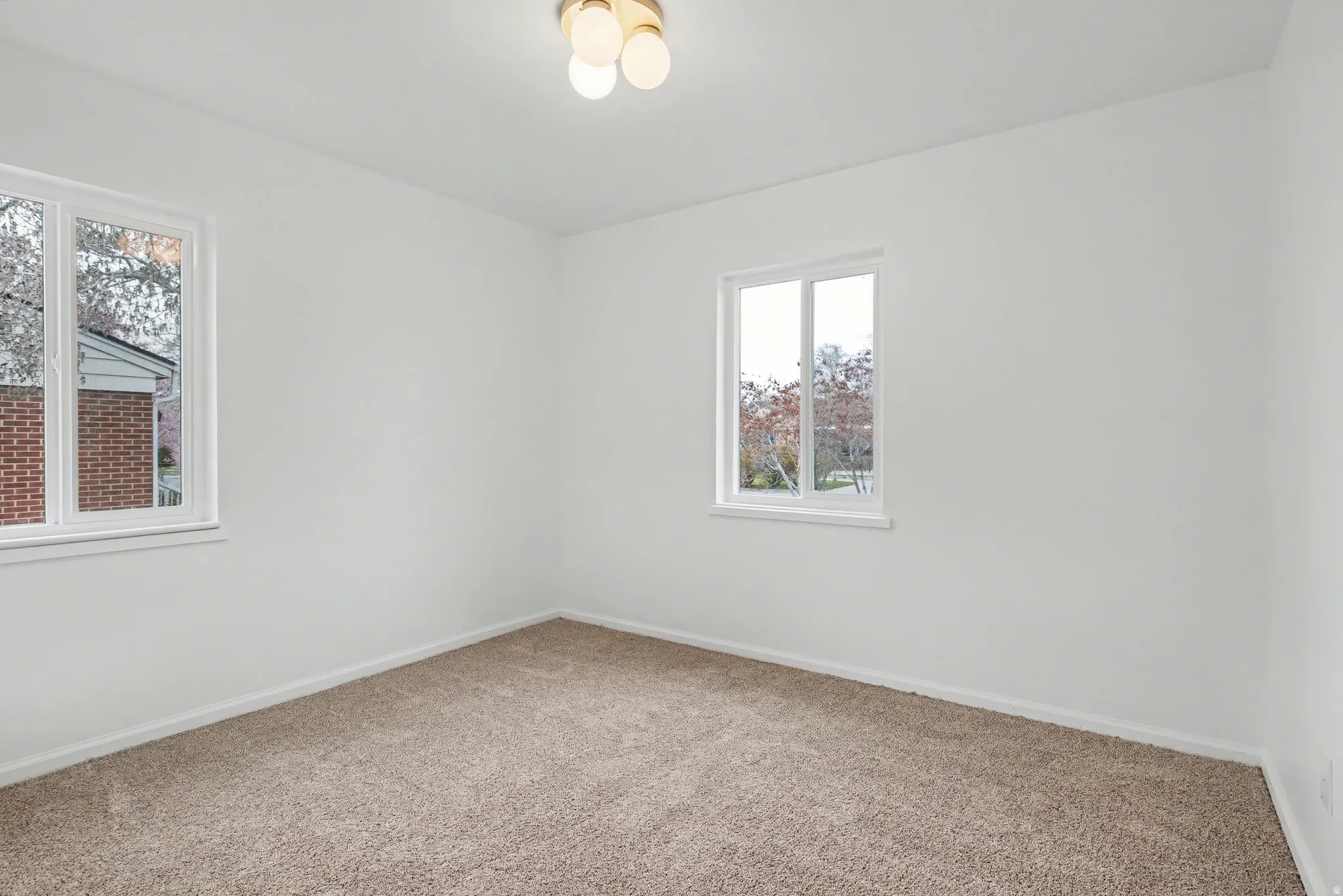 Spare room featuring carpet flooring and baseboards