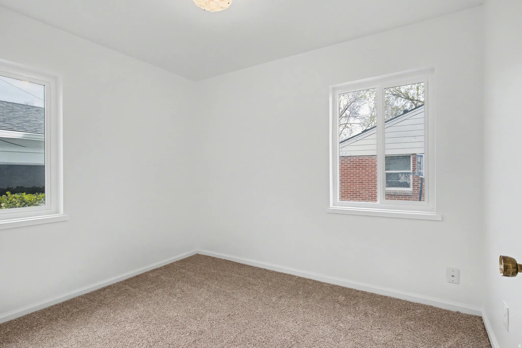Carpeted spare room featuring baseboards