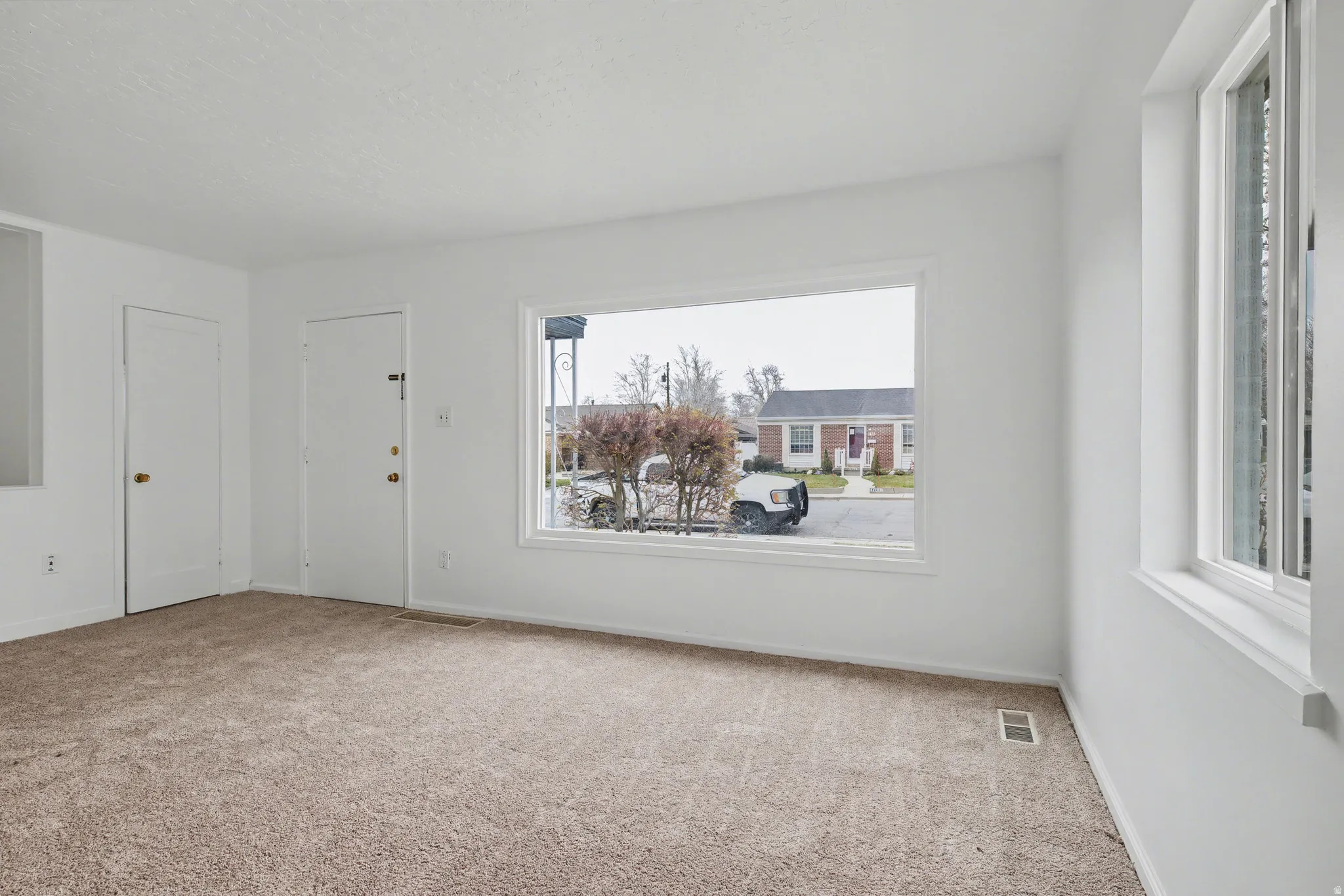 Empty room featuring light carpet and baseboards