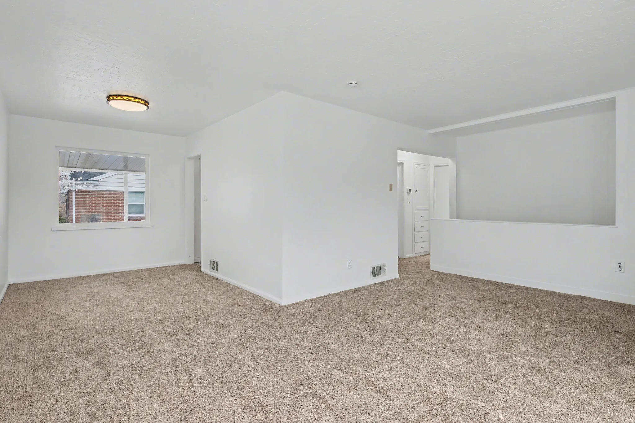 Unfurnished room with light colored carpet and baseboards