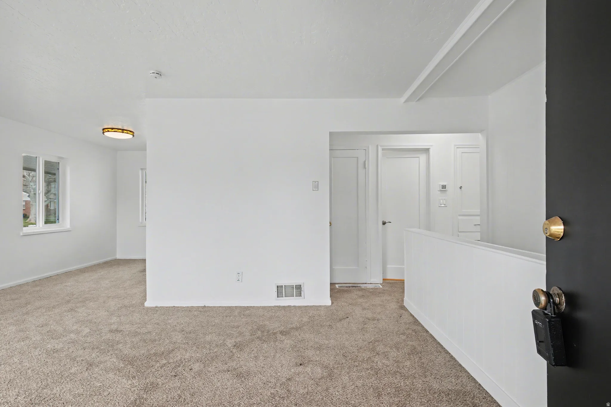 Spare room with light carpet and baseboards