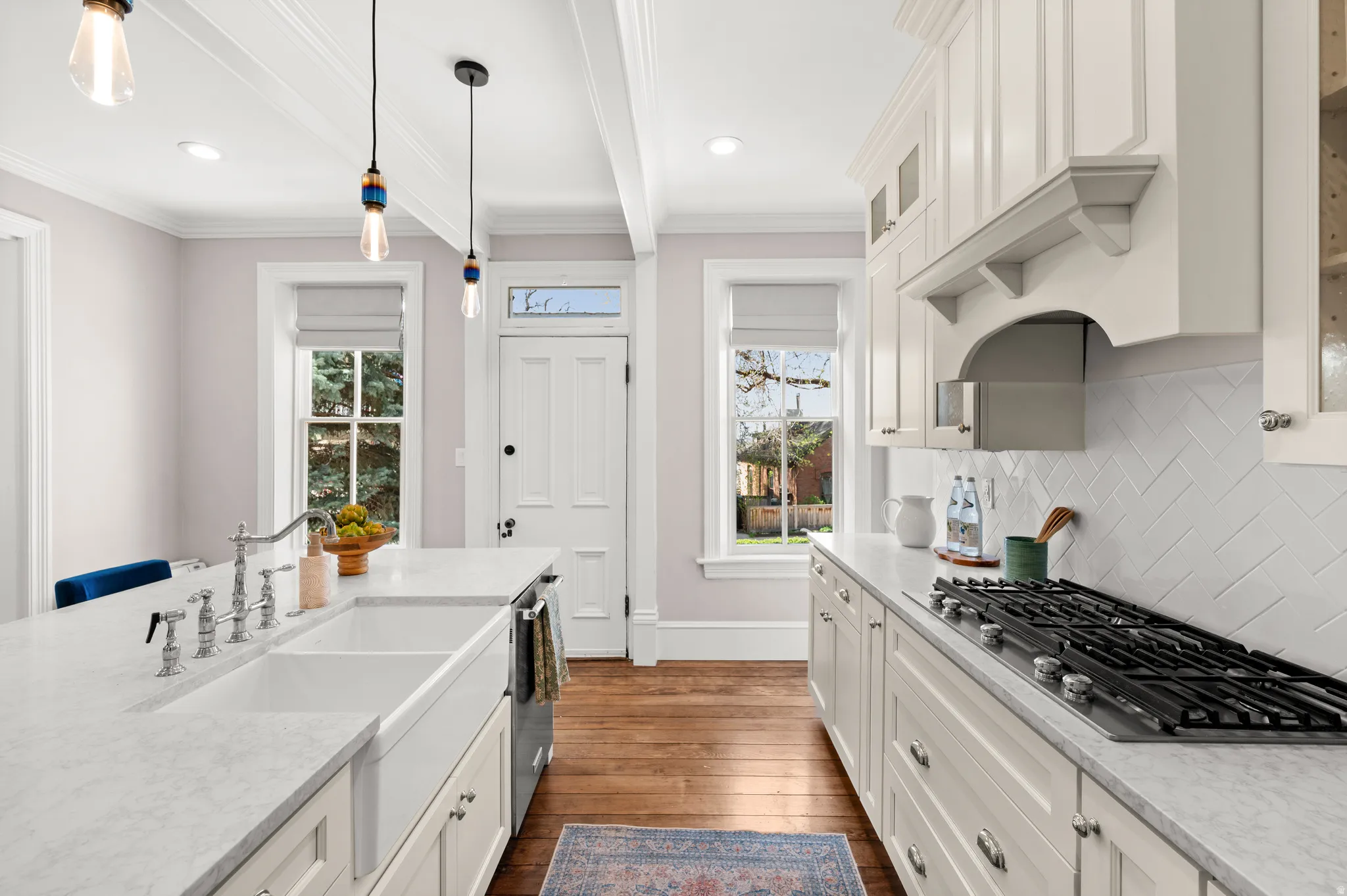 Kitchen featuring white cabinetry, stainless steel appliances, beamed ceiling, dark wood finished floors, and glass insert cabinets