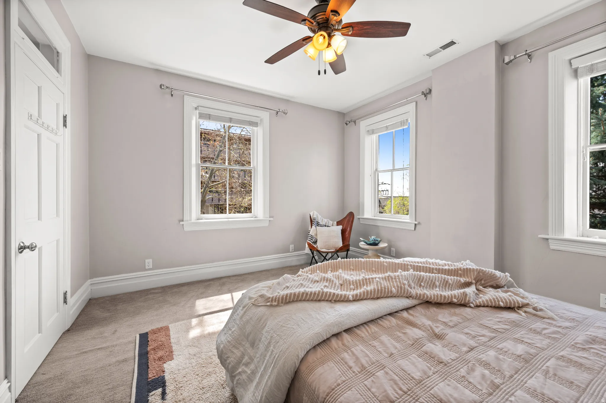 Carpeted bedroom with a ceiling fan and baseboards