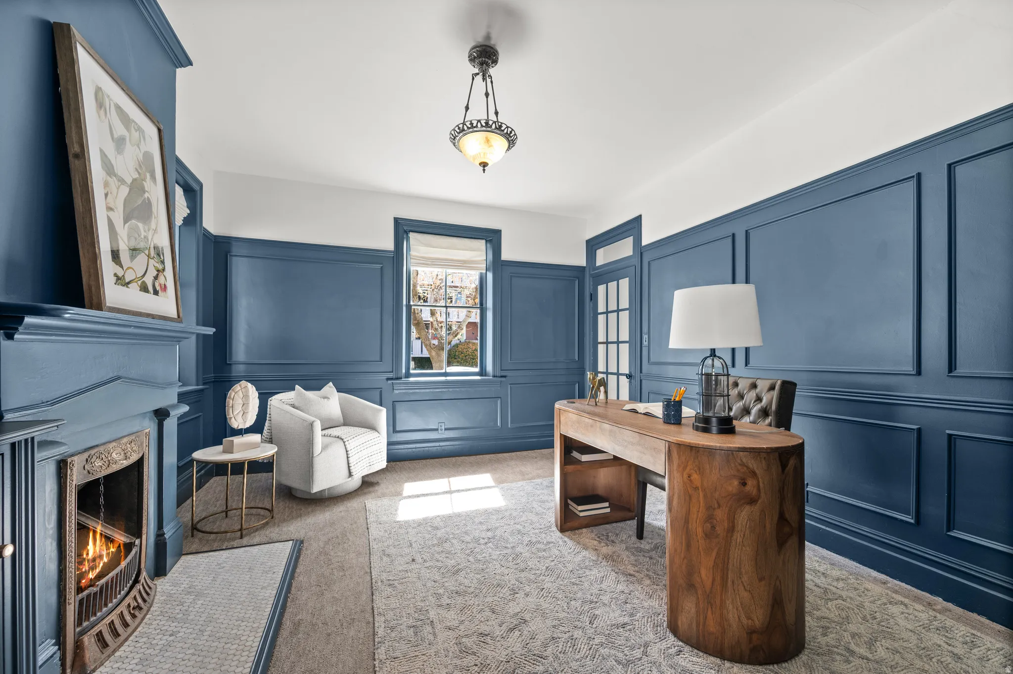 Home office featuring a decorative wall, carpet floors, and a high end fireplace