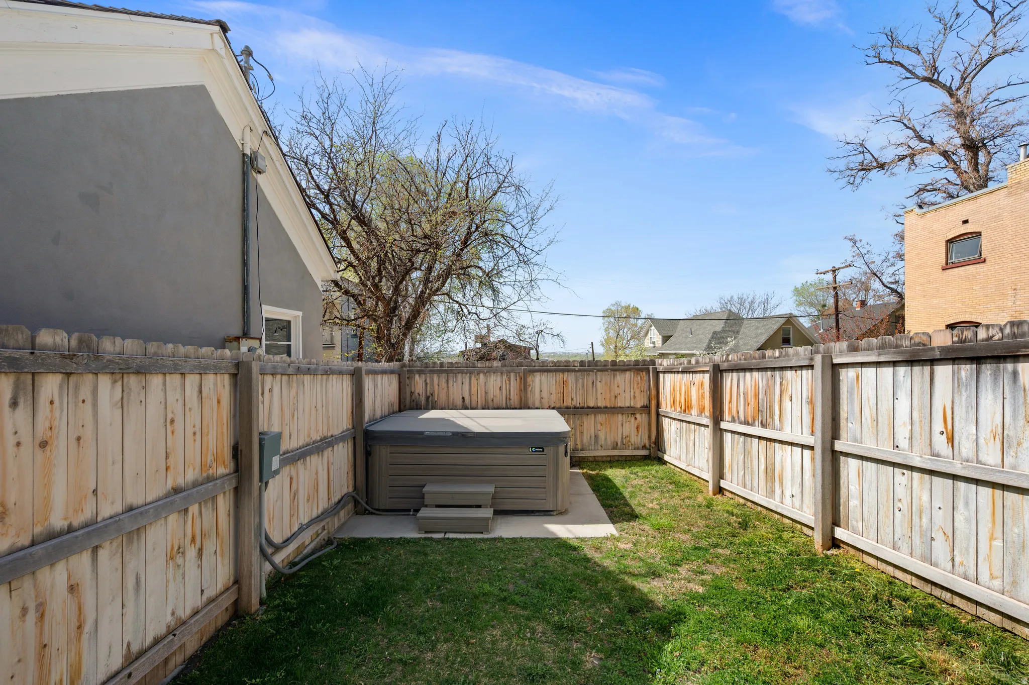 Fenced backyard featuring a hot tub and a residential view