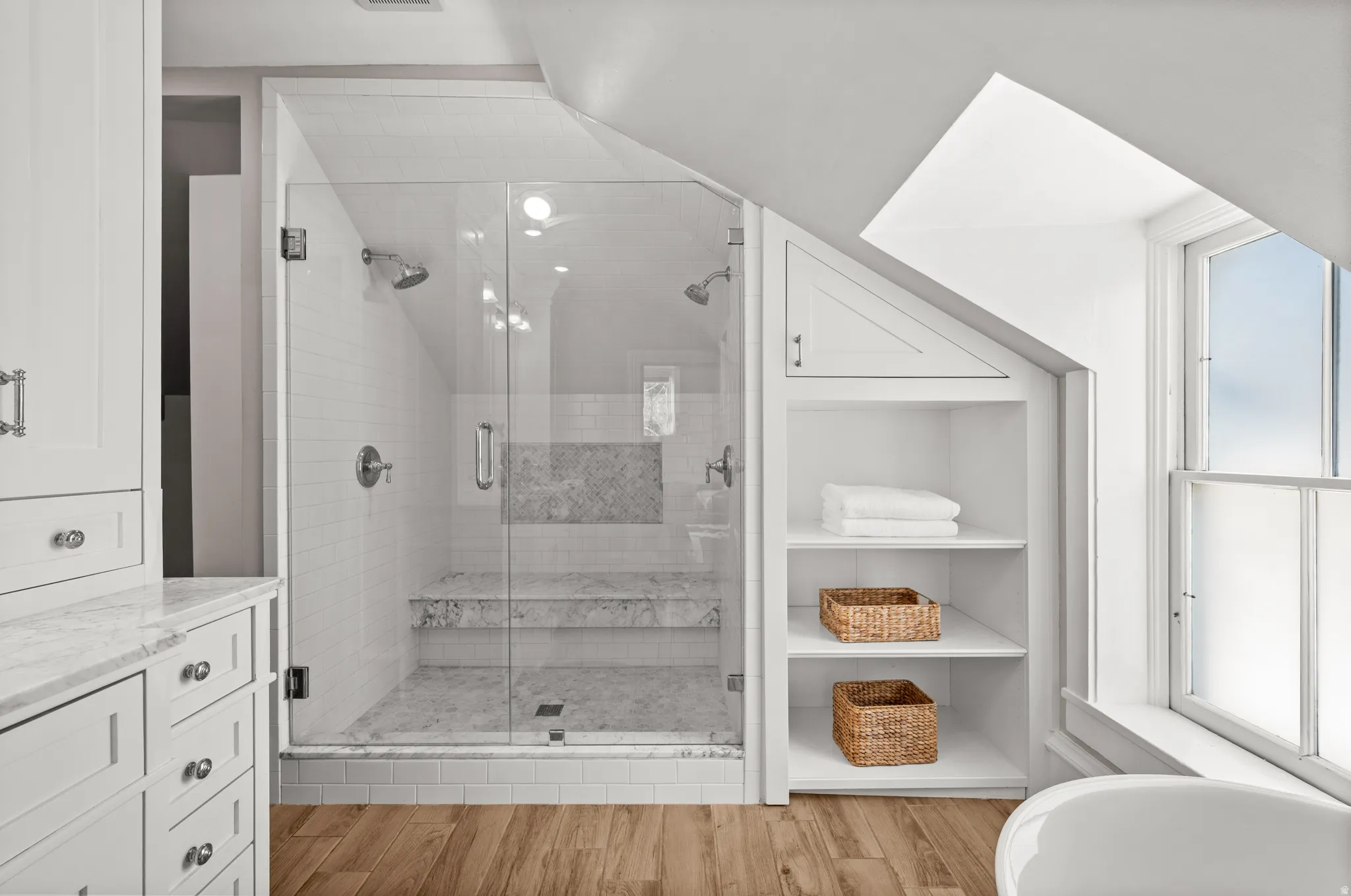 Full bathroom featuring light wood finished floors, a stall shower, and vanity