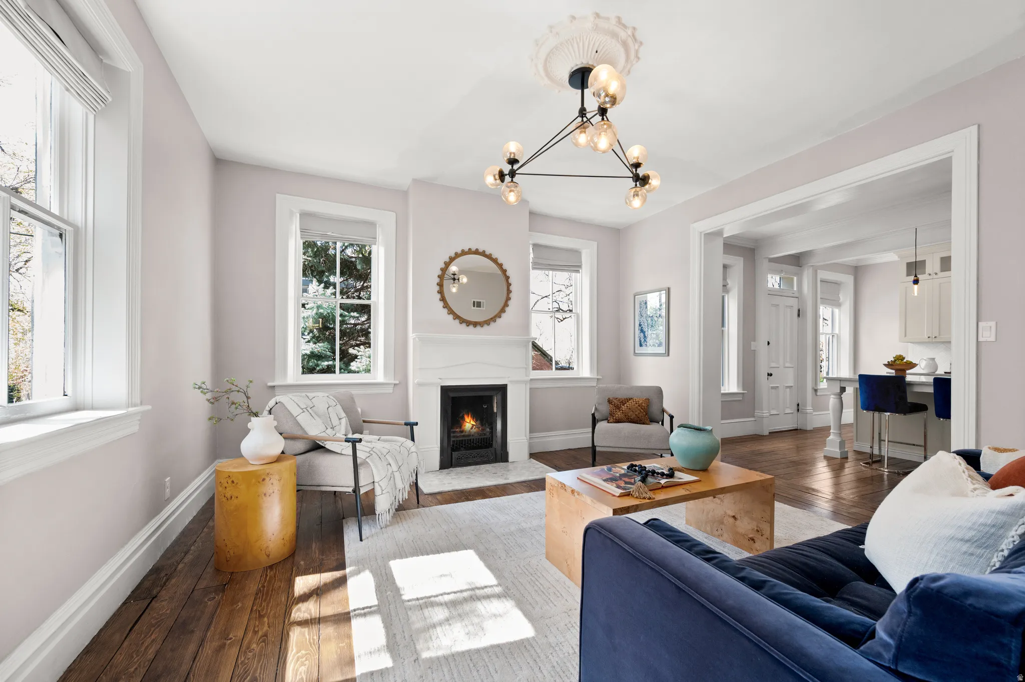 Living room featuring a fireplace with flush hearth, hardwood / wood-style flooring, and hanging lights