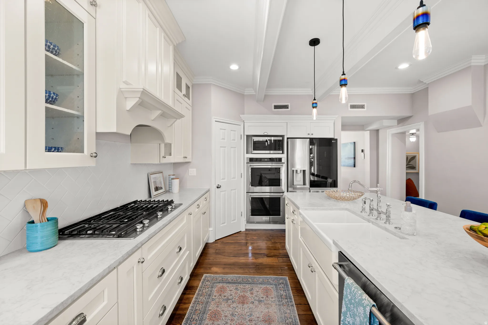 Kitchen with white cabinetry, hanging light fixtures, beam ceiling, glass fronted cabinets, and stainless steel appliances