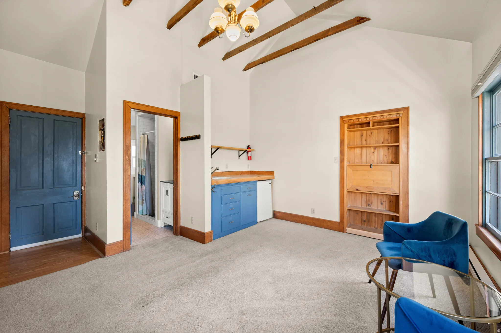 Sitting room with carpet floors, vaulted ceiling, and a baseboard radiator