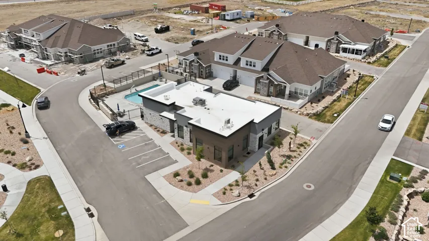 Community building featuring a swimming pool with surrounding fence and patio area, adjacent to multi-unit residential structures