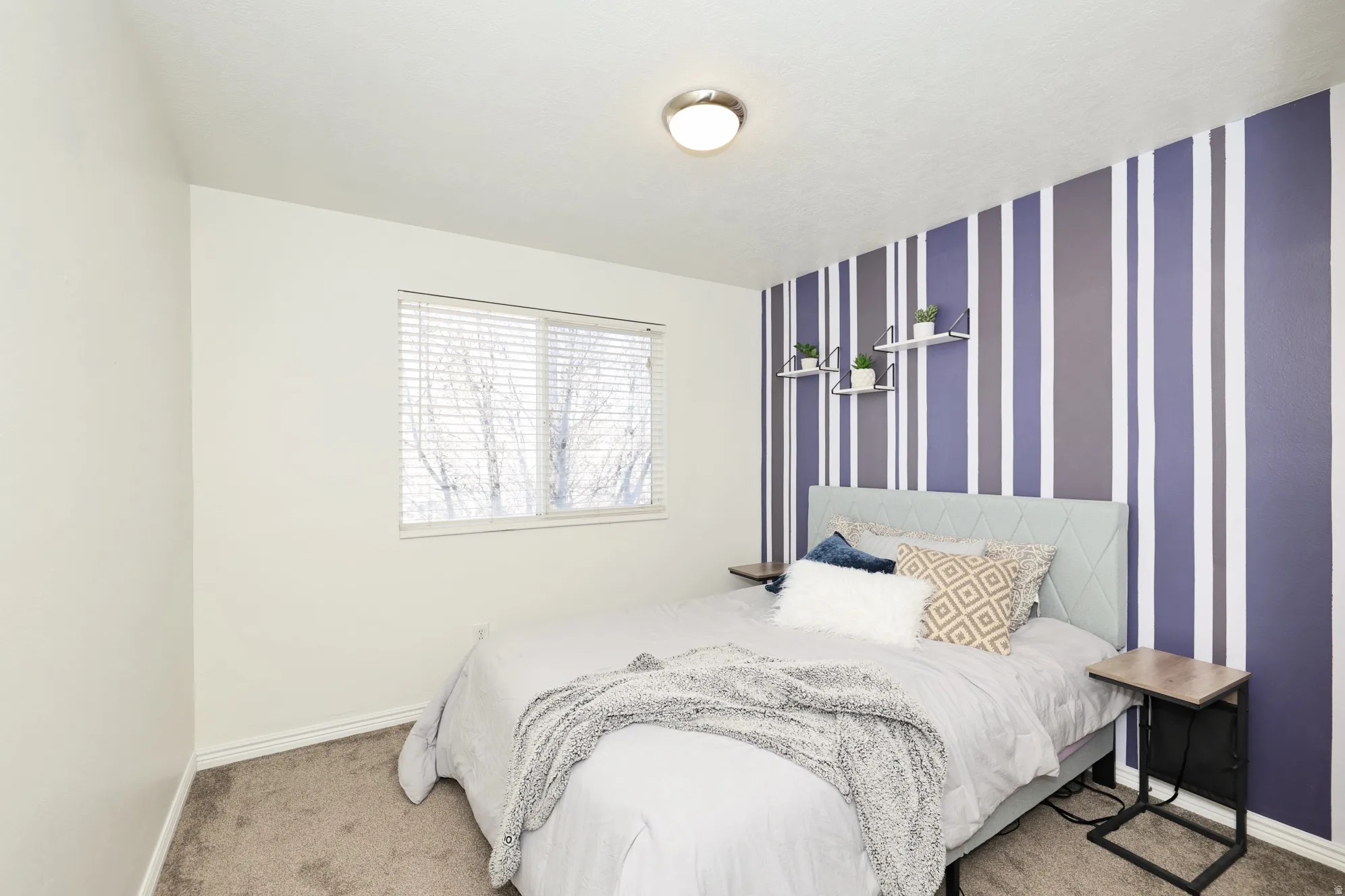 Bedroom with carpet flooring, wallpapered walls, and an accent wall