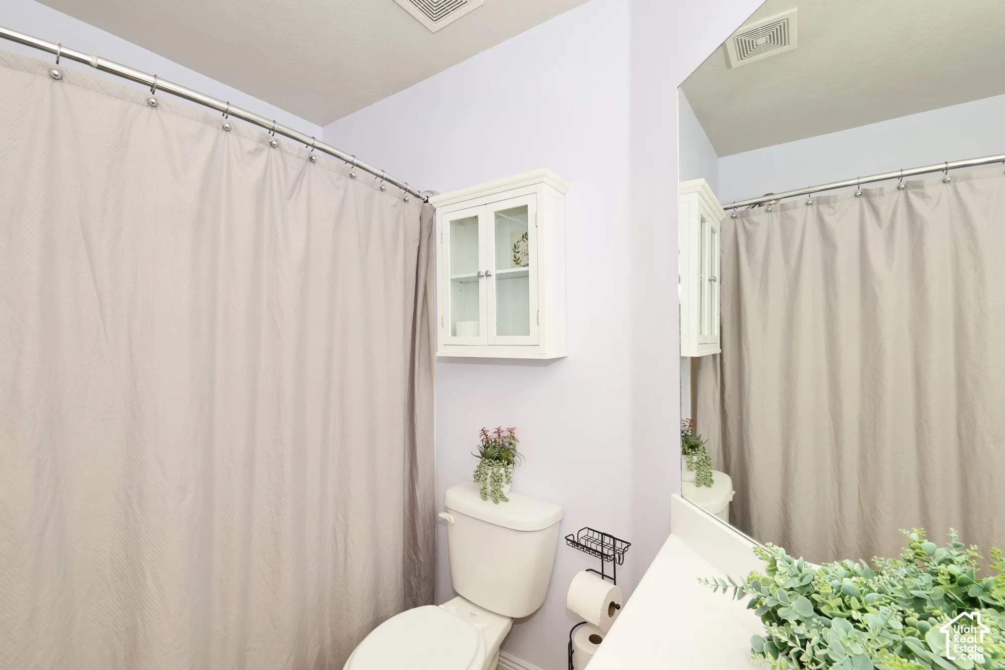 Bathroom with toilet and a shower with curtain