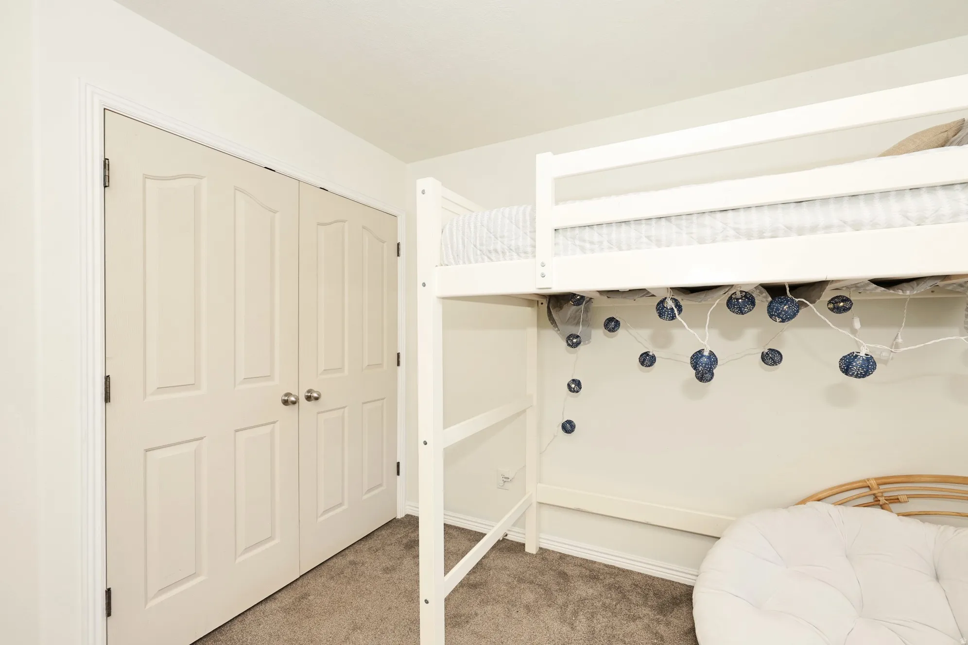 Bedroom featuring light carpet and a closet