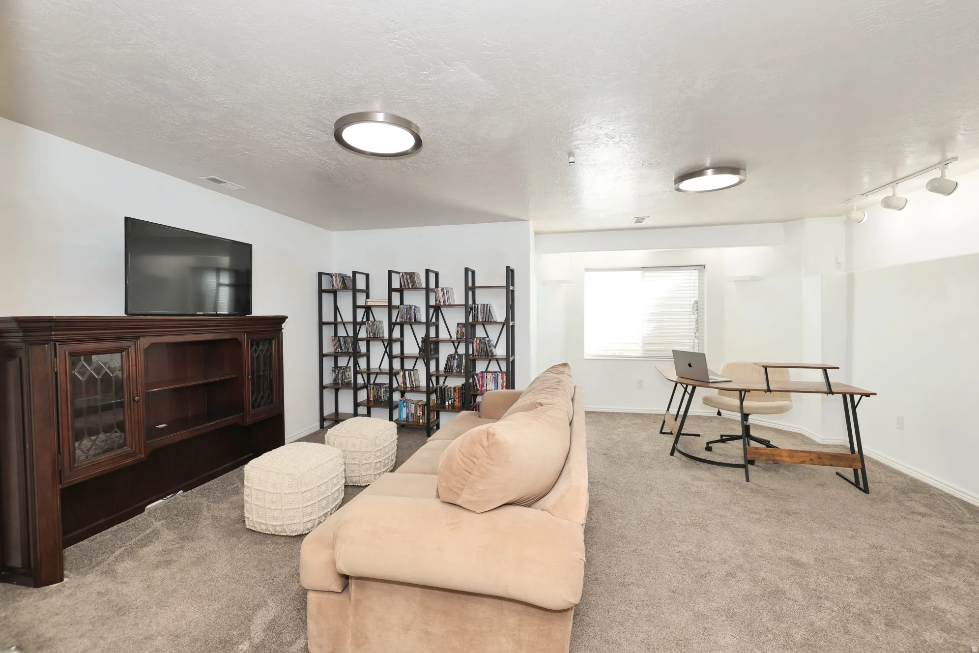 Sitting room featuring carpet floors, a textured ceiling, and rail lighting