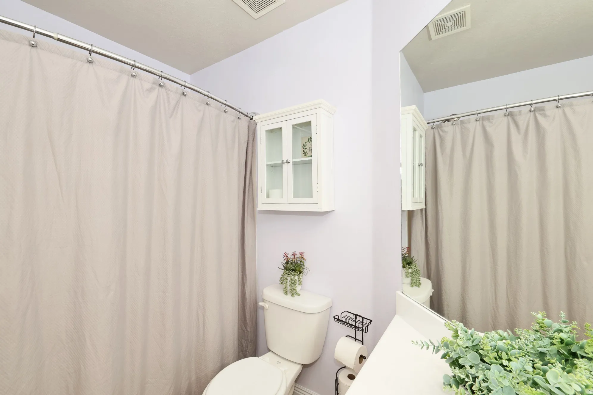 Bathroom with toilet and a shower with curtain