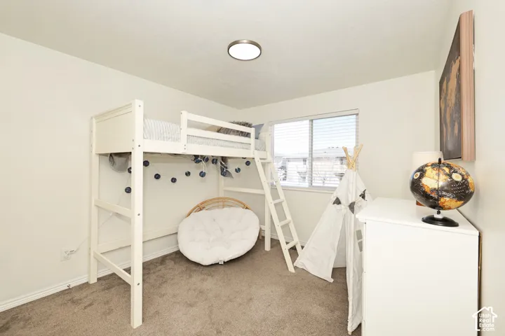 Bedroom with light carpet and baseboards