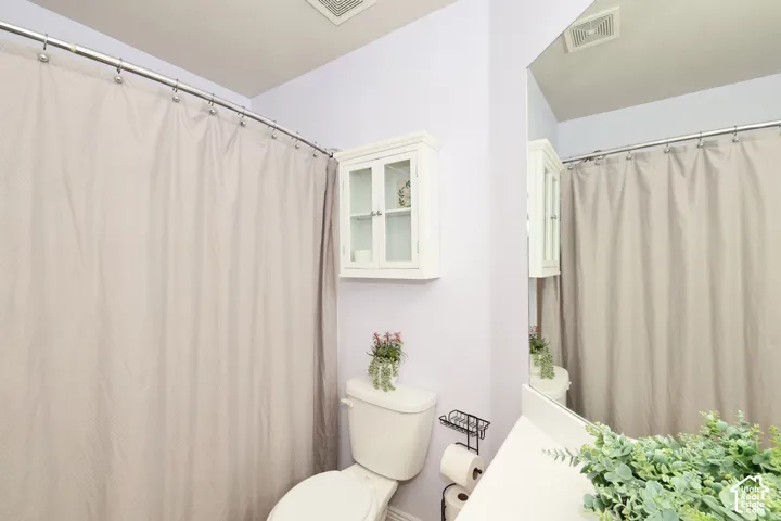 Bathroom with toilet and a shower with curtain