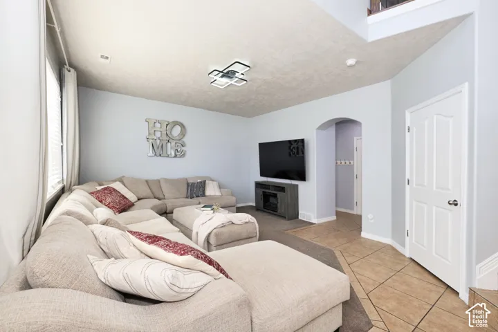 Living room with arched walkways and light tile patterned flooring