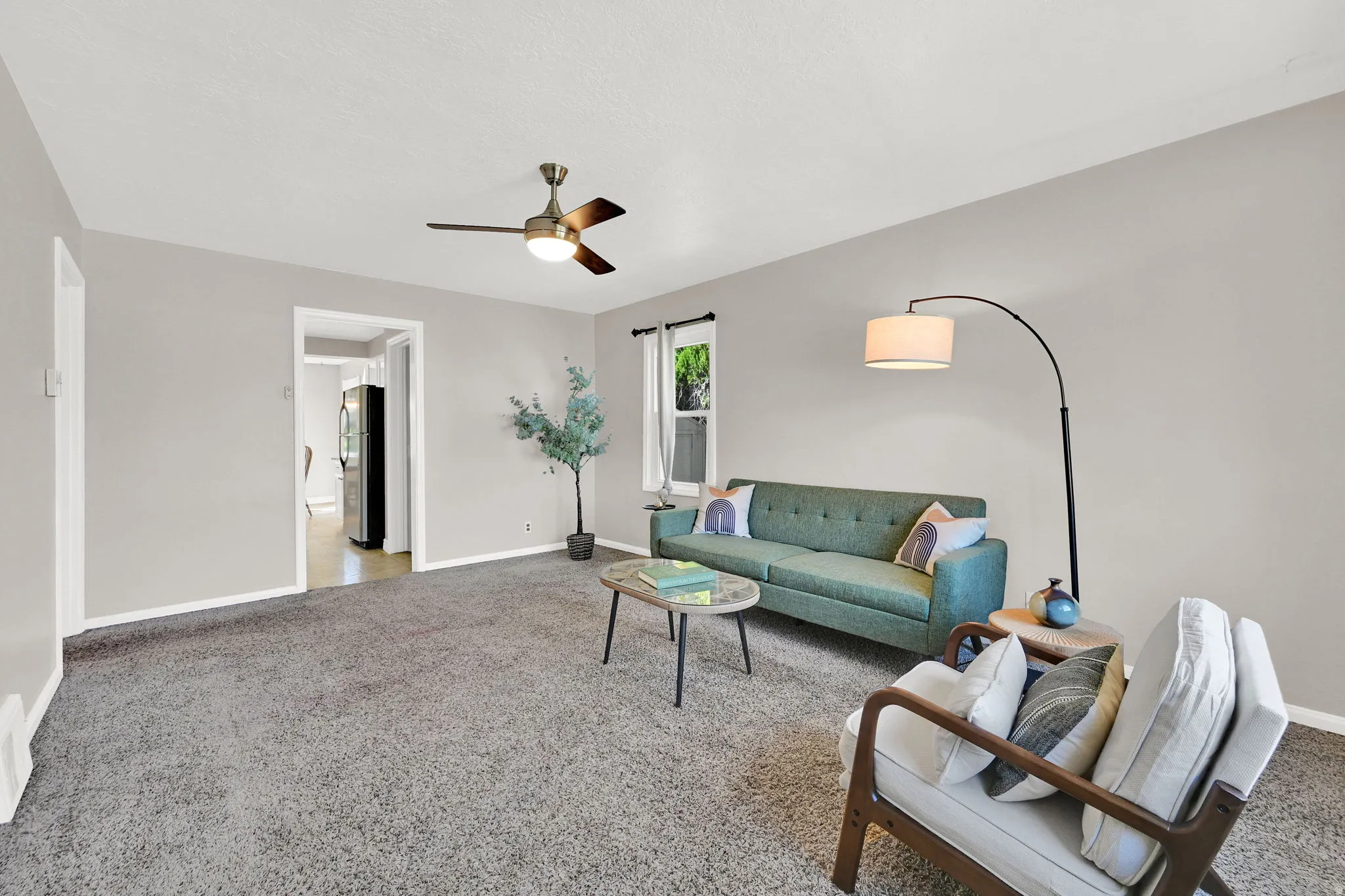 Living room featuring carpet flooring and a ceiling fan
