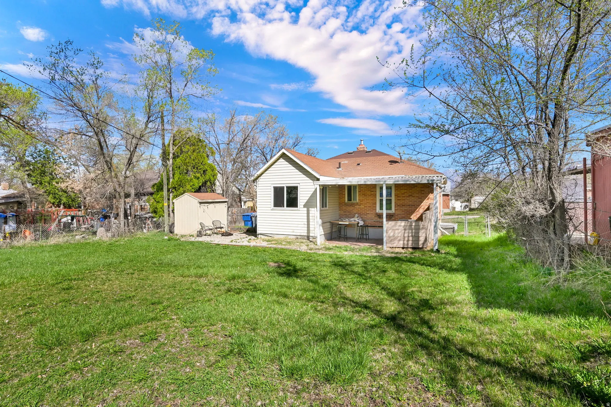 Back of property featuring a patio, a storage unit, and a chimney