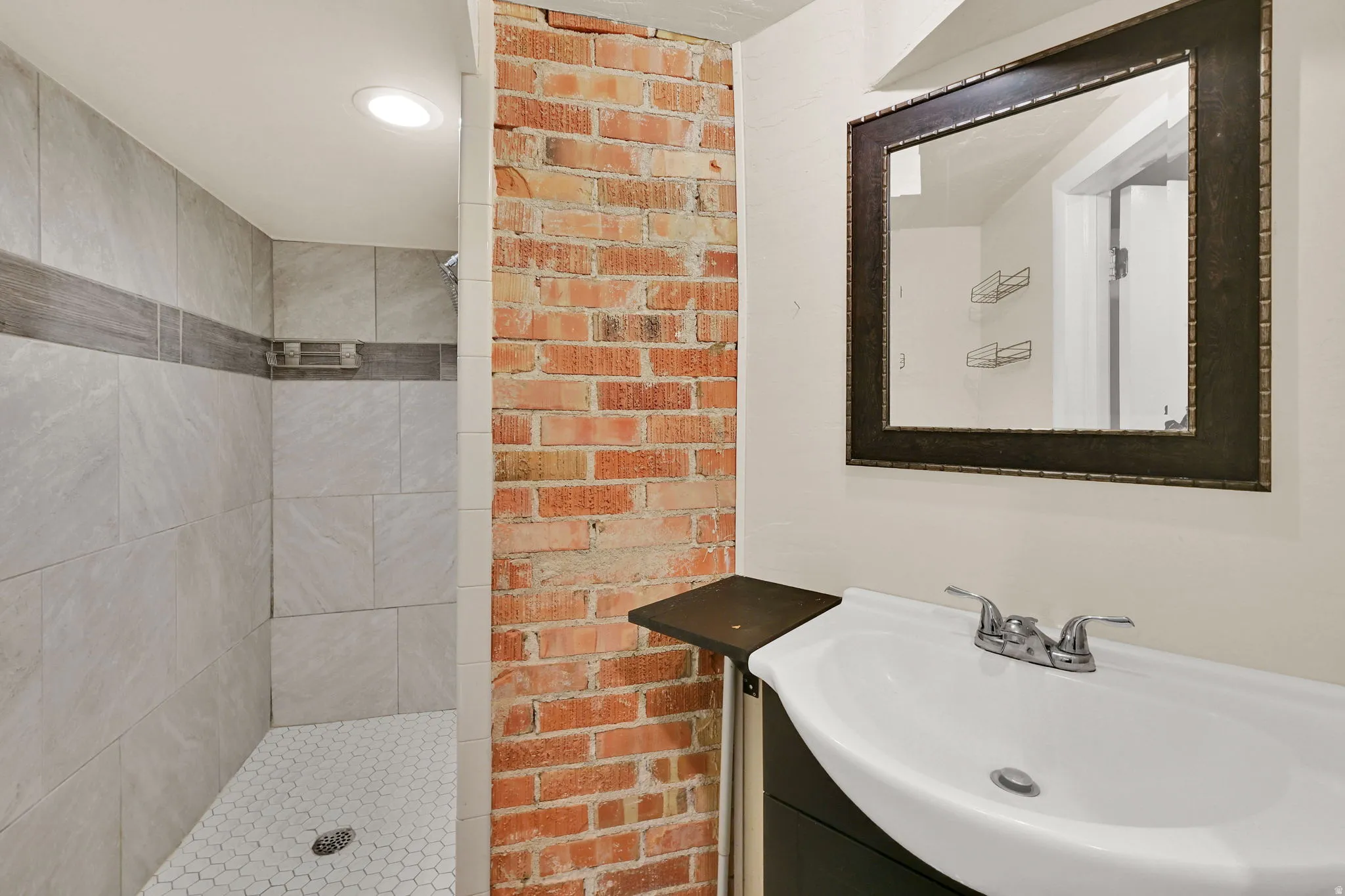 Bathroom featuring vanity, tiled shower, and recessed lighting
