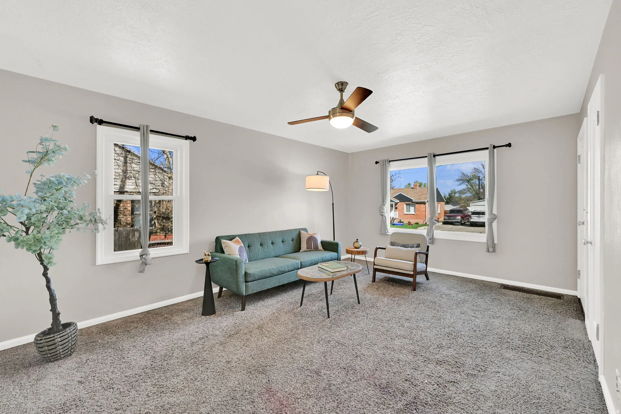 Living room with ceiling fan and light carpet