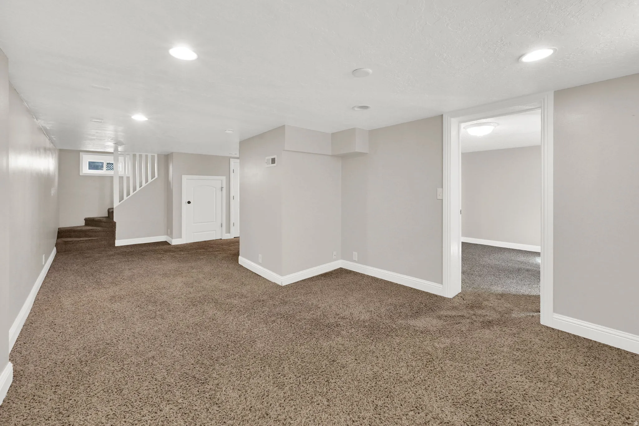 Finished basement featuring dark colored carpet, recessed lighting, and a textured ceiling