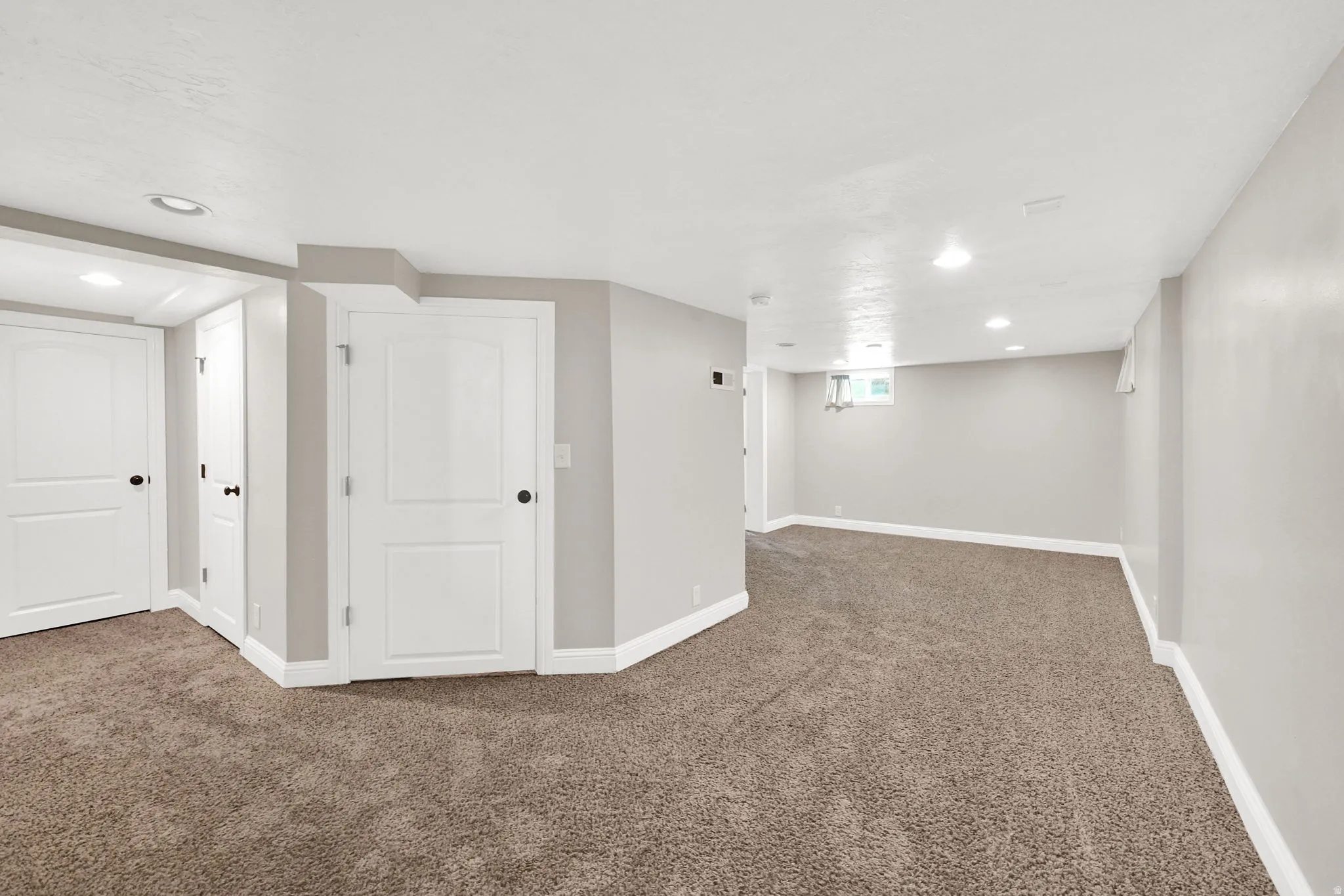 Below grade area featuring dark carpet and recessed lighting