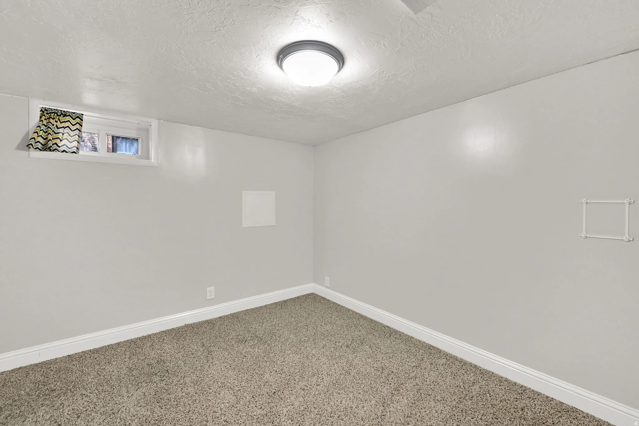 Basement featuring a textured ceiling and carpet floors