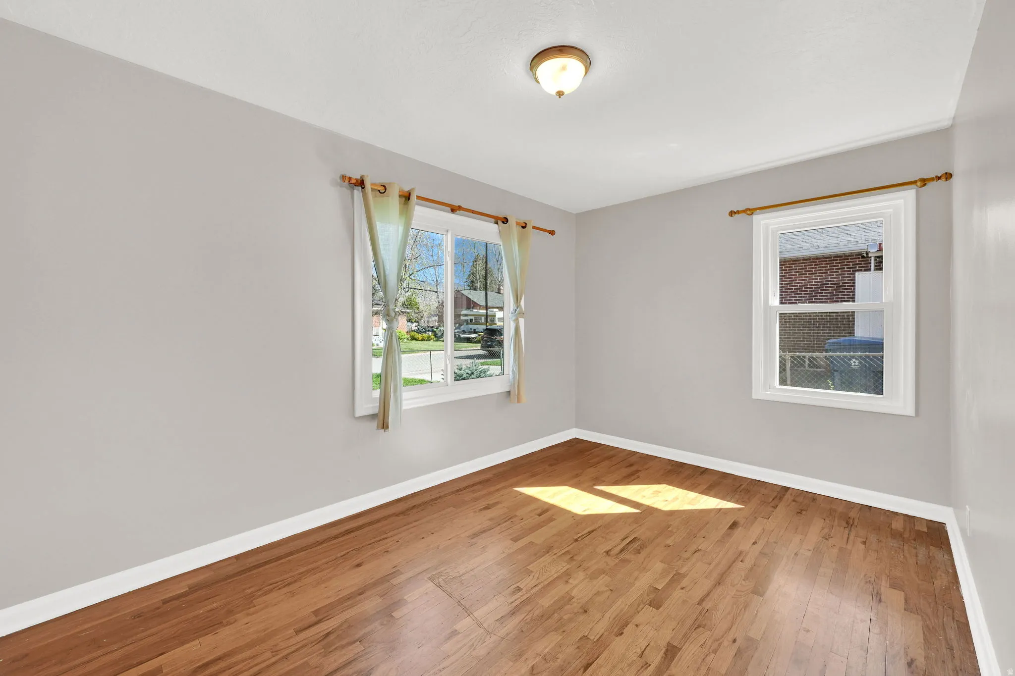Spare room featuring baseboards and light wood-style flooring