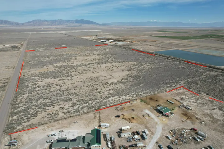 Aerial view of sparsely populated area featuring a mountain backdrop and property boundaries highlighted