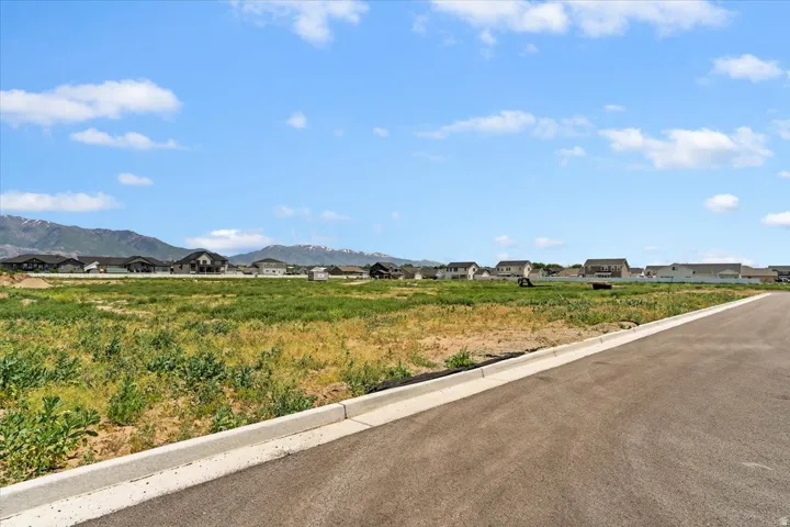 View of asphalt street with curbs, a mountain view, and a residential view