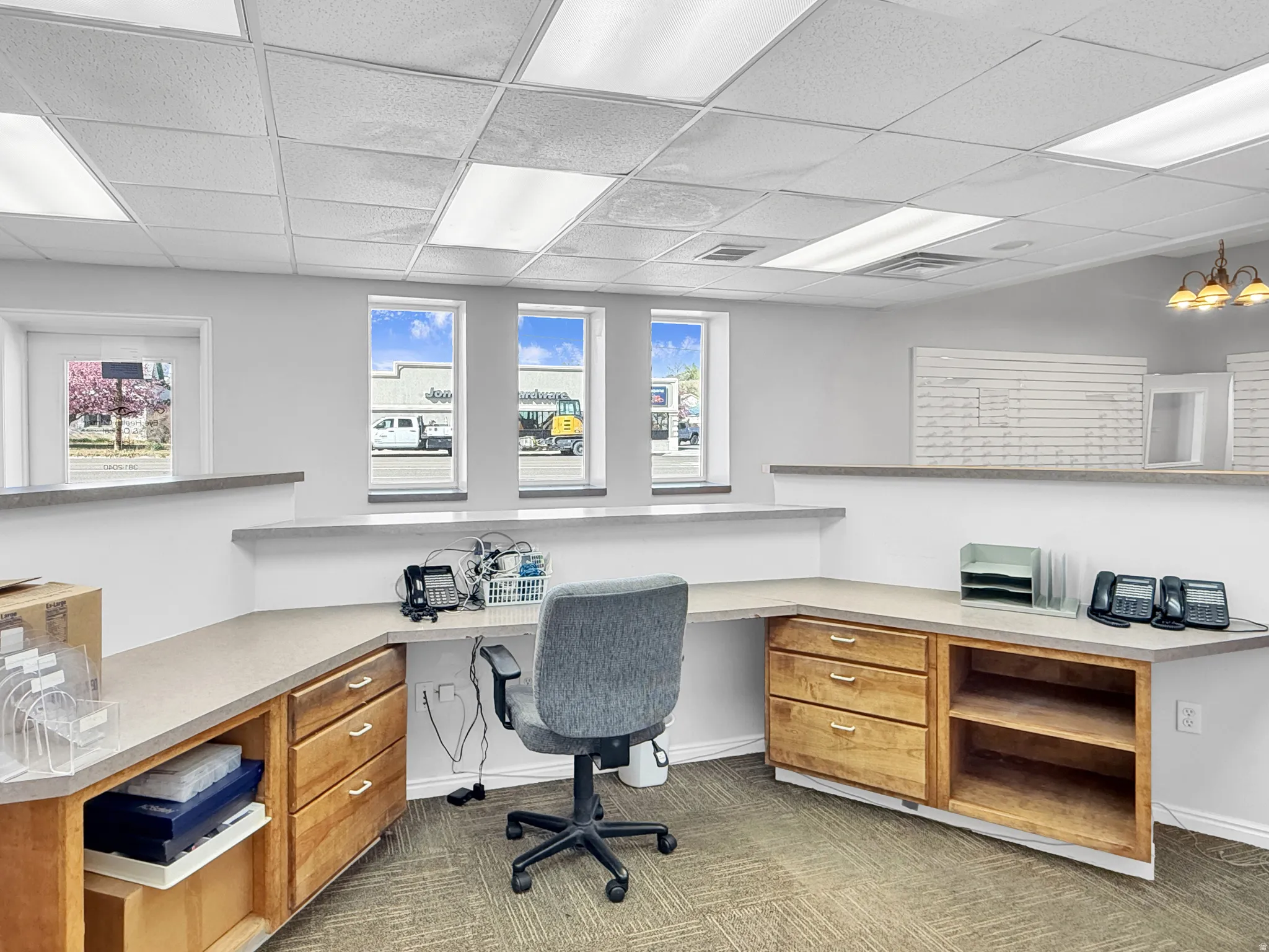 Office space with a paneled ceiling, built in study area, and healthy amount of natural light
