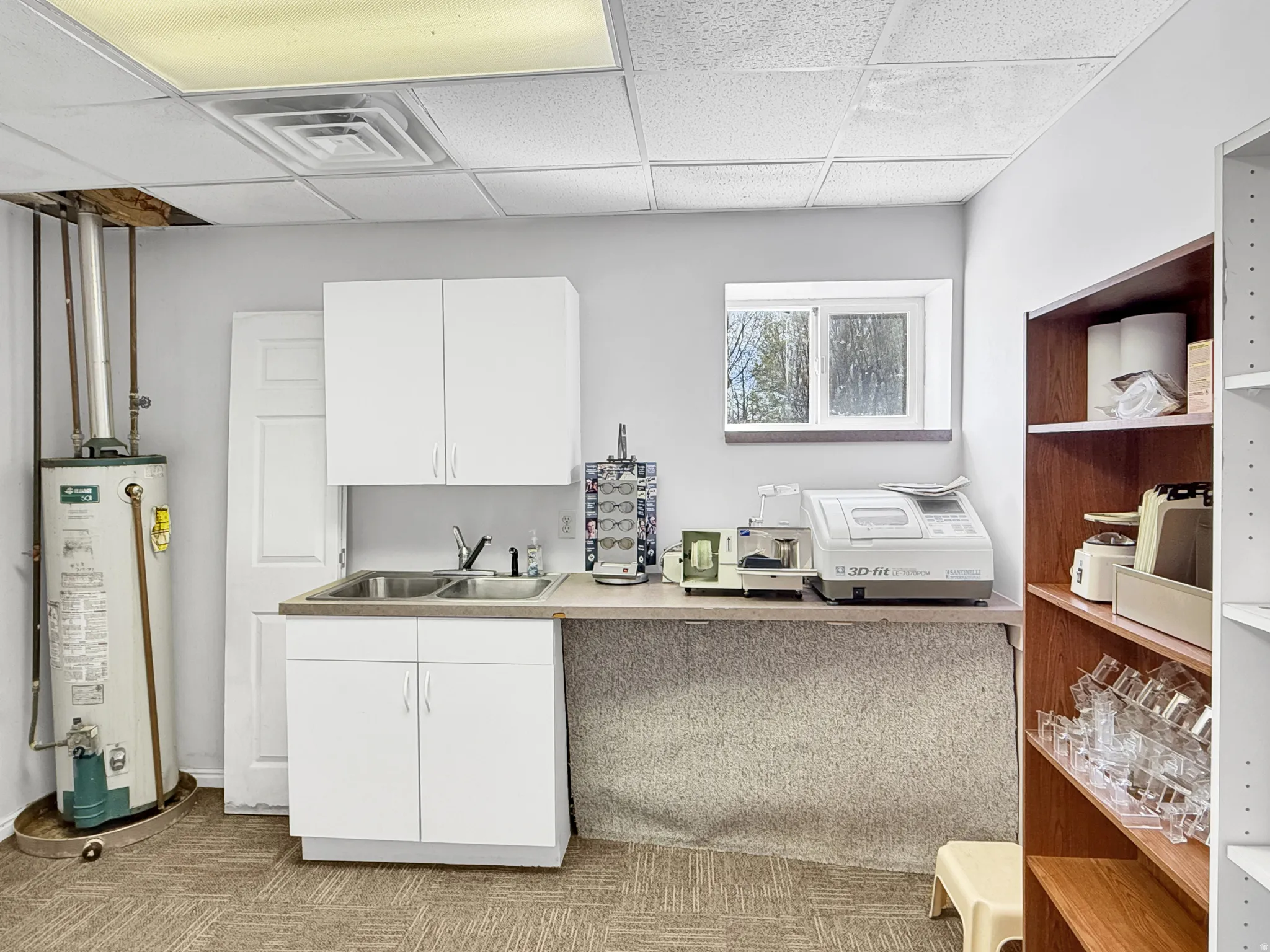 Bar area with a paneled ceiling, white cabinets, water heater, and light countertops