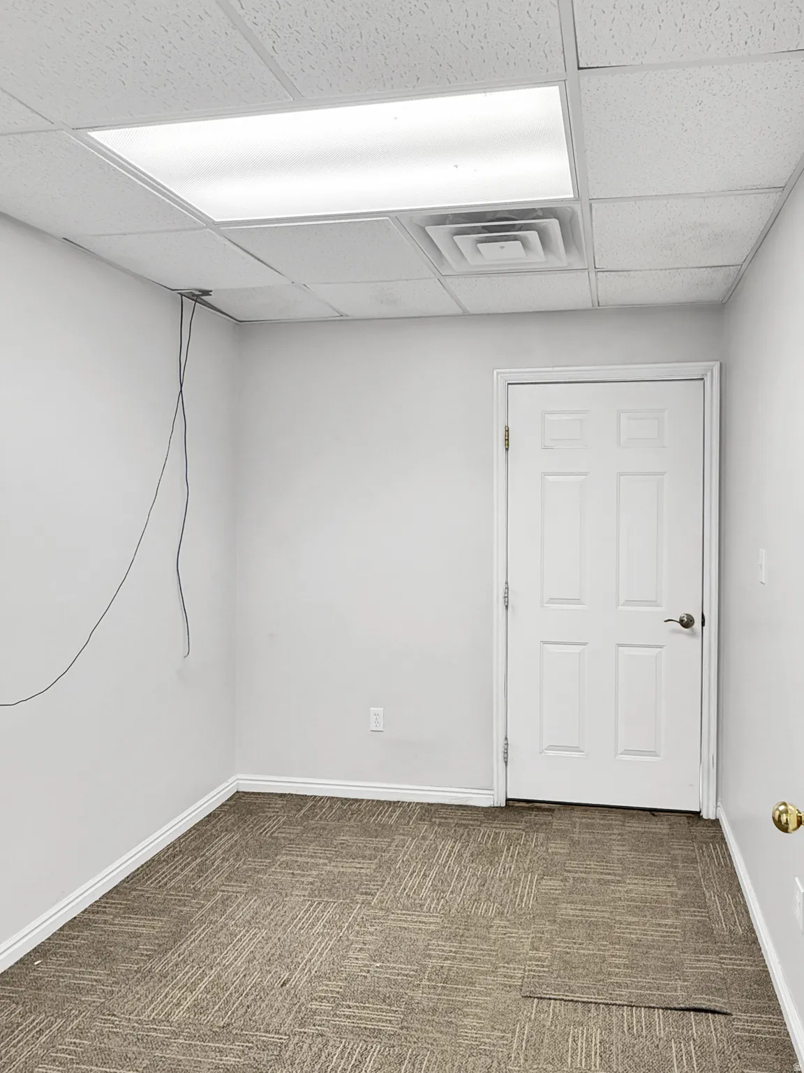 Below grade area with dark carpet and a paneled ceiling