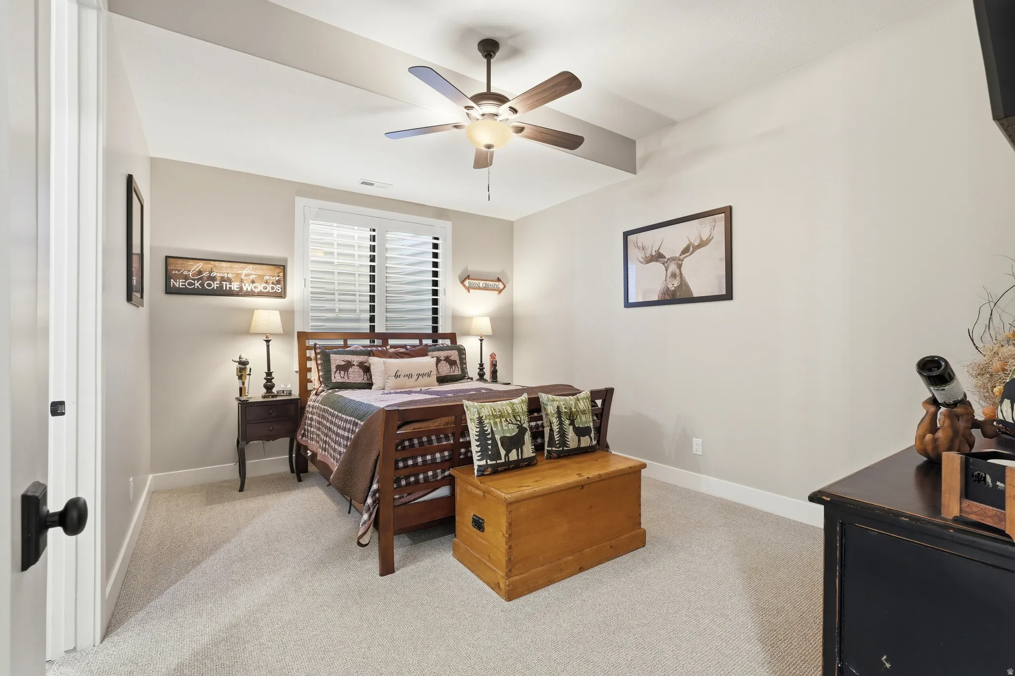 Bedroom with light colored carpet and a ceiling fan